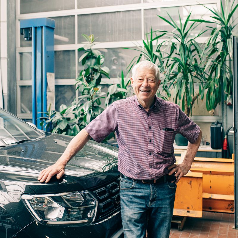 Werner Schumacher, Geschäftsführer, steht vor einem Fahrzeug in der Werkstatt