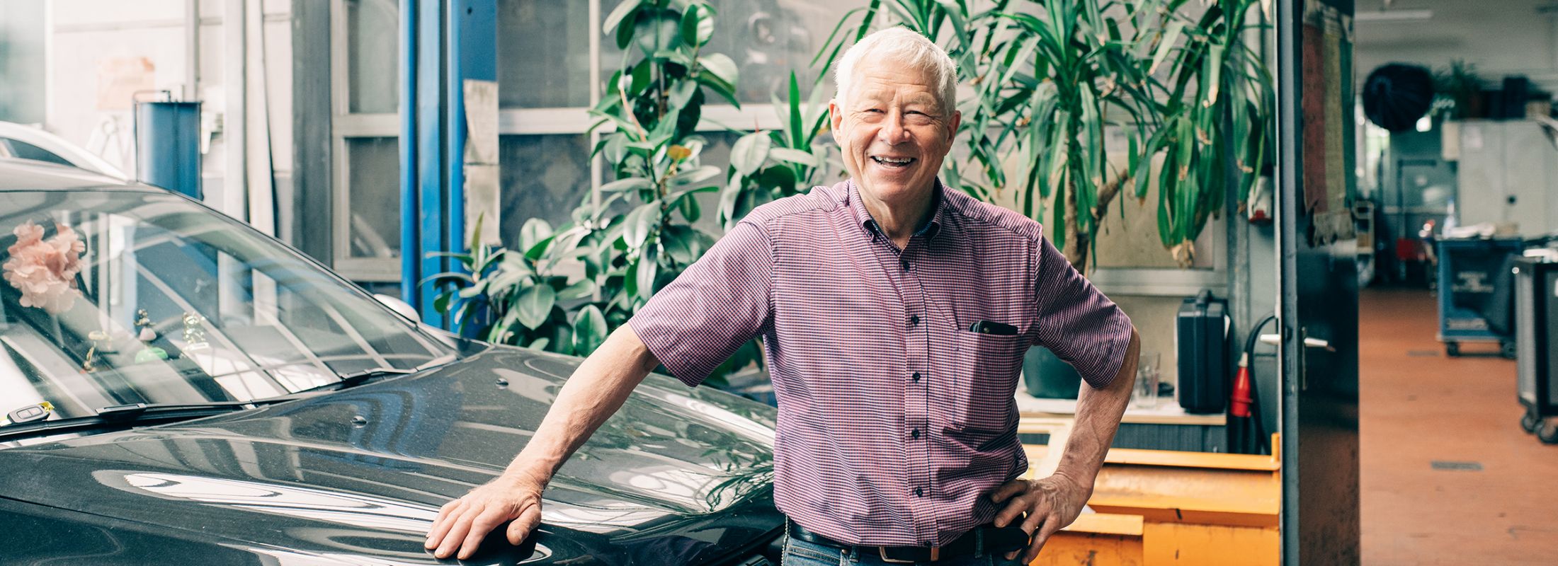 Werner Schumacher, Geschäftsführer, steht vor einem Fahrzeug in der Werkstatt